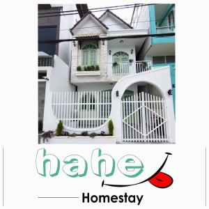 大叻HaHe Homestay的白色的房子,有白色的大门,文字有家居