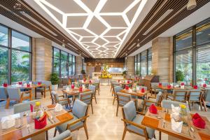 绥和市Rosa Alba Resort & Villas Tuy Hoa的餐厅设有桌椅和窗户。