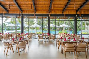 绥和市Rosa Alba Resort & Villas Tuy Hoa的一间带桌椅的餐厅和一个游泳池