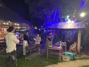 高平Luong Son Homestay Ecolodge的一群人晚上站在帐篷外