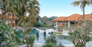 普卡诺伟司吉里度假酒店及水疗中心的一座带喷泉和棕榈树的度假村内的游泳池