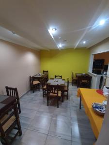 埃尔卡拉法特Hostel Danny的用餐室设有桌椅和黄色的墙壁