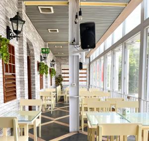 普禾加多Hotel Wisata Niaga Campus的用餐室设有桌椅和窗户。