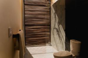 塞隆贝拉纳克DUNIA LOMBOK - Villas with Ocean View的一间带卫生间的浴室和一个带百叶窗的窗户