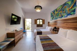 瓦哈卡市NaNa Vida Hotel Oaxaca的酒店客房配有两张床和一张书桌