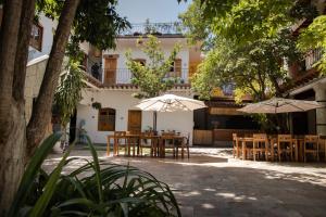 瓦哈卡市NaNa Vida Hotel Oaxaca的大楼前带桌子和遮阳伞的天井