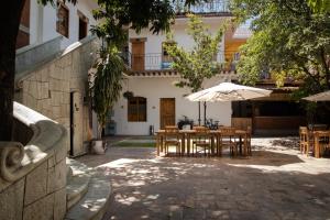 瓦哈卡市NaNa Vida Hotel Oaxaca的一个带桌子和遮阳伞的庭院