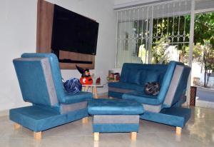 吉拉尔多特Casa Vacacional con Jacuzzi en Girardot Cundinamarca的客厅配有2把蓝色椅子和电视