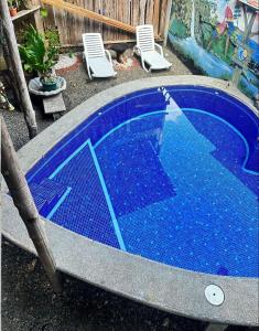 塔尔科莱斯Hostel Rústico MarAbi的四周设有椅子的小蓝色游泳池