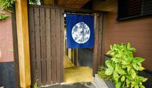 别府Kamegawa Onsen HATAGO Yuyu的挂在房子门口的国旗