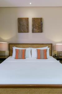 爱妮岛巴莱阿德劳酒店的一间卧室配有一张带两盏灯的大型白色床。