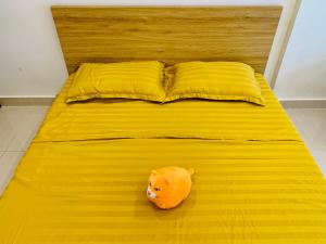 Gò CôngBao Vy's Cozy House的一只橙色的动物坐在黄色的床边