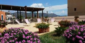 圣马里纳萨利纳坎纳塔酒店的庭院内摆放着椅子和鲜花,后面是群山