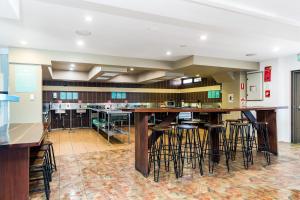 拜伦湾Aquarius Backpackers Resort的一个大厨房,内设一个带凳子的大酒吧