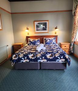 Okoroire奥克鲁利温泉酒店的一间卧室配有一张带蓝色棉被的床