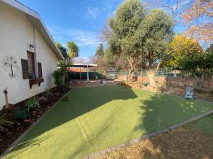 布隆方丹Aloe Guest Rooms的房屋前带绿色草坪的院子