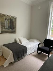 图尔库Old Turku Family Apartment的白色卧室配有床和椅子