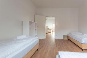 杜伊斯堡T&K Apartments - DUISBURG - Frisch renovierte 4 Zimmer Maisonetten mit Privatparkplätzen的配有白色墙壁和木地板的客房内的两张床