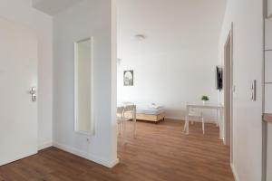 杜伊斯堡T&K Apartments - DUISBURG - Frisch renovierte 4 Zimmer Maisonetten mit Privatparkplätzen的客厅拥有白色的墙壁和木地板