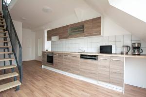 杜伊斯堡T&K Apartments - DUISBURG - Frisch renovierte 4 Zimmer Maisonetten mit Privatparkplätzen的一间带木制橱柜和楼梯的厨房