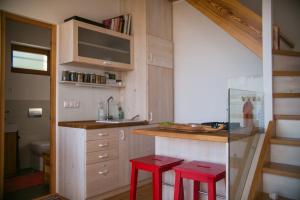 塞克萨德Ég & Föld Borvendégház的一个带两个红色凳子和水槽的小厨房