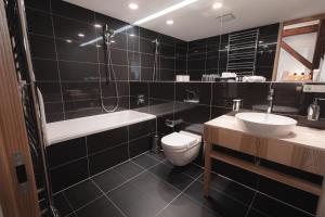 布拉迪斯拉发Hotel ALBRECHT的浴室配有卫生间、浴缸和水槽。