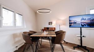 维也纳URBAN ISLAND I Riverside Apartments的用餐室配有桌椅和平面电视。