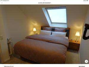 克洛彭堡Wohnung mit Whirlpool, Nähe Thülsfelder Talsperre的一间卧室配有一张带窗户和两盏灯的床。