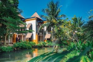 卡伦海滩Paradox Resort Phuket - SHA Plus的前面有一条河的房子