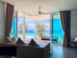 卡伦海滩Paradox Resort Phuket - SHA Plus的带沙发的客厅,享有海景