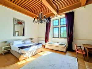 Sainte-Julie文艺复兴酒店的一间卧室配有一张床、一张桌子和一个吊灯。