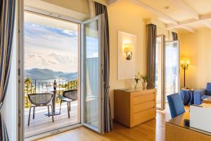 卡迪马里奥Kurhaus Cademario Hotel & DOT Spa - Ticino Hotels Group的带阳台的客房设有一扇门