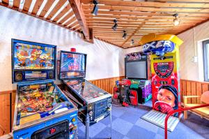 雷加霍斯达哈施莱塔瓦永乡村俱乐部度假村的一间设有两个街机游戏和电视的房间