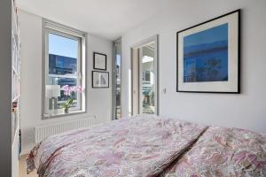 奥斯陆Modern 2bed room sea view apartment @ Oslo Barcode的一间卧室设有一张床和两个窗户。