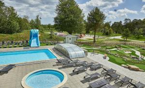福勒Sudersand Resort的一个带椅子和水滑梯的游泳池