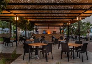 迪迪姆Maya World Didyma Hotel的一个带桌椅的庭院和一间酒吧