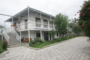 库塔伊西Guest House Nona的白色的大建筑,设有楼梯和庭院