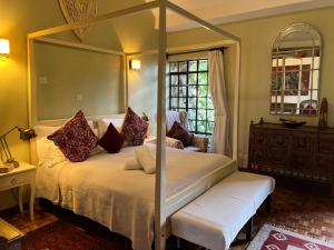 内罗毕霍布之家旅馆的一间卧室配有一张四柱天蓬床