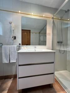 安道尔城艾尔塞奇公寓式酒店的浴室配有白色水槽和淋浴。
