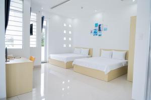 Tây NinhAn Gia Hotel Tây Ninh的一间卧室配有两张床和一张书桌