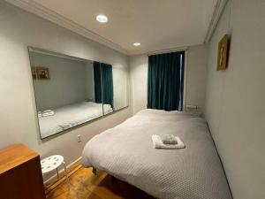 布鲁克林Fawlty Towers的一间卧室配有一张床和一面大镜子