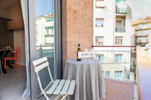 阿斯蒂Arò Design Suite的阳台上的桌椅和一瓶葡萄酒