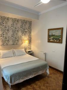 贝赫尔-德拉弗龙特拉Casa en la Corredera的卧室配有一张床,墙上挂有绘画作品