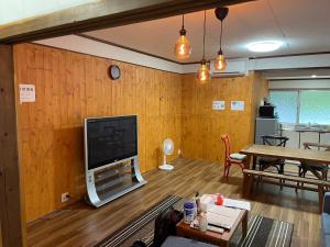 濑户内町Koniyado Room 101 - Vacation STAY 42374v的客厅设有木墙,配有平面电视。