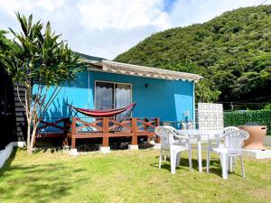 濑户内町Koniyado Room 101 - Vacation STAY 42374v的庭院里带桌椅的蓝色房子