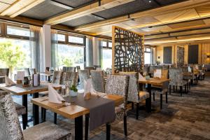 巴特欣德朗DIE GAMS Hotel Restaurant的用餐室设有桌椅和窗户。