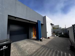 斯瓦科普蒙德5078 Swakopmund的一座建筑,里面有一个车库,有一个蓝色的杆
