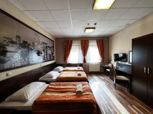 热舒夫梅什科酒店的酒店客房设有三张床和一张书桌