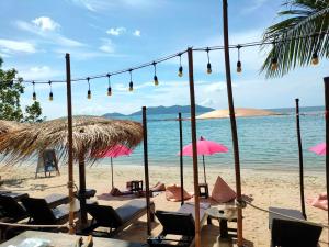 象岛海滩咖啡厅旅馆的海滩上设有椅子和遮阳伞,还有大海