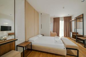 伏罗拉Hotel Central的卧室配有一张白色大床和电视。